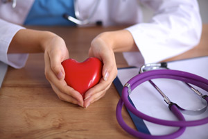 Female Physicians is holding an heart shaped object in her hands