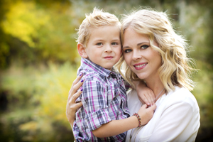 Young mother holding her toddler son smiling.